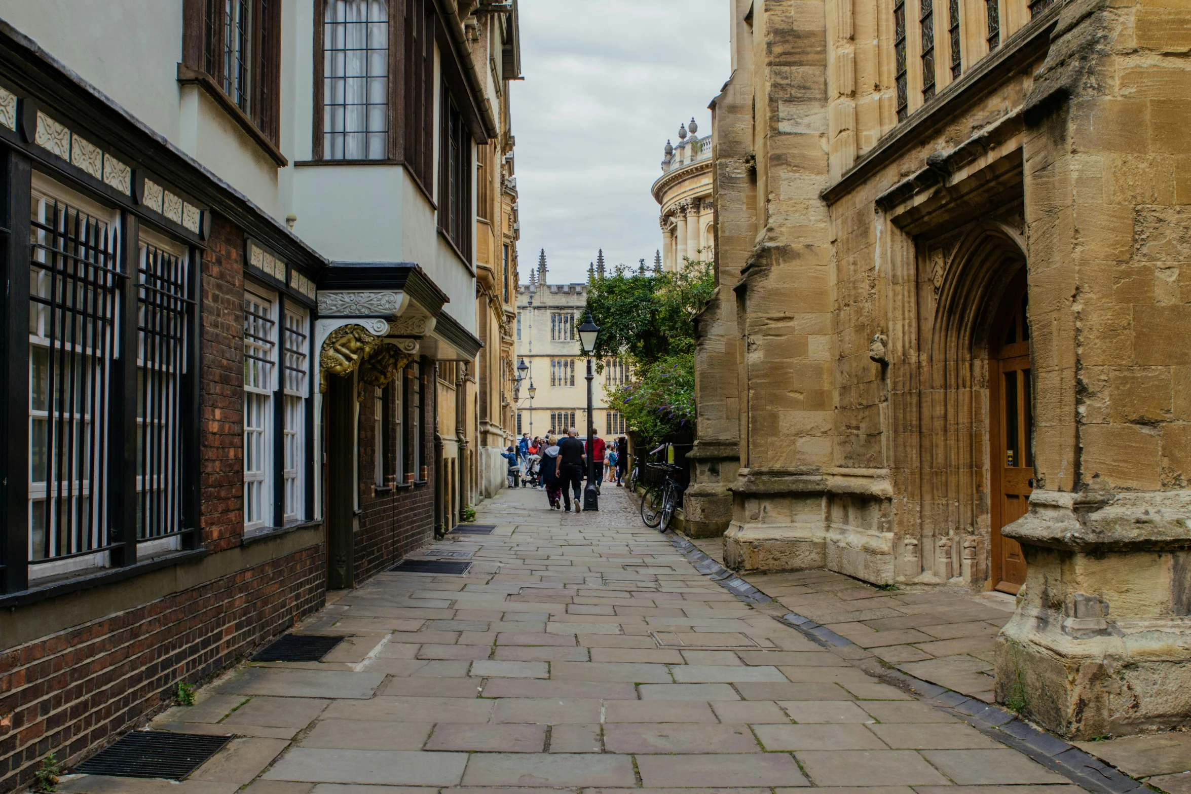 several people are walking down an old stone city street