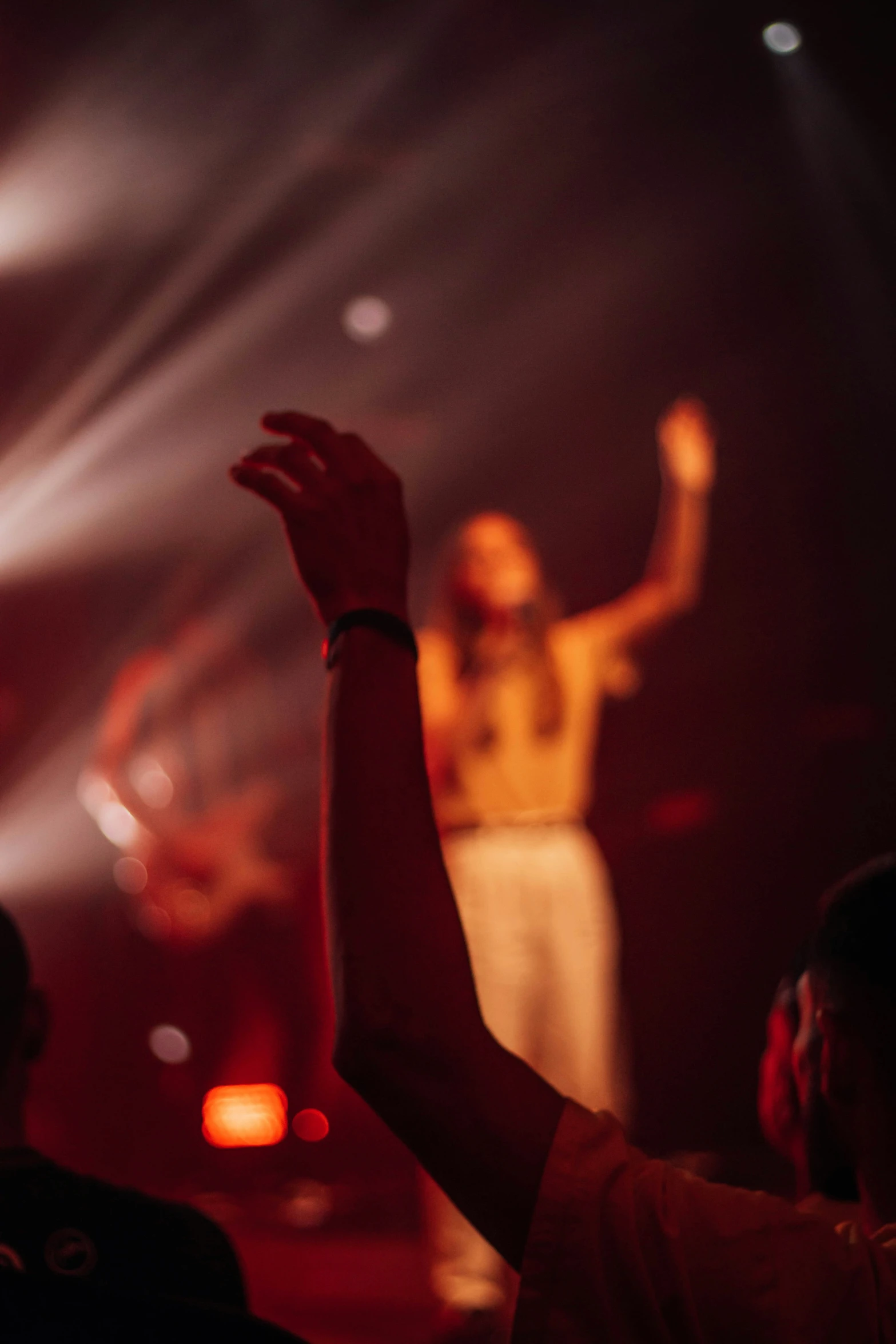 several people on stage and a person holding their hands up