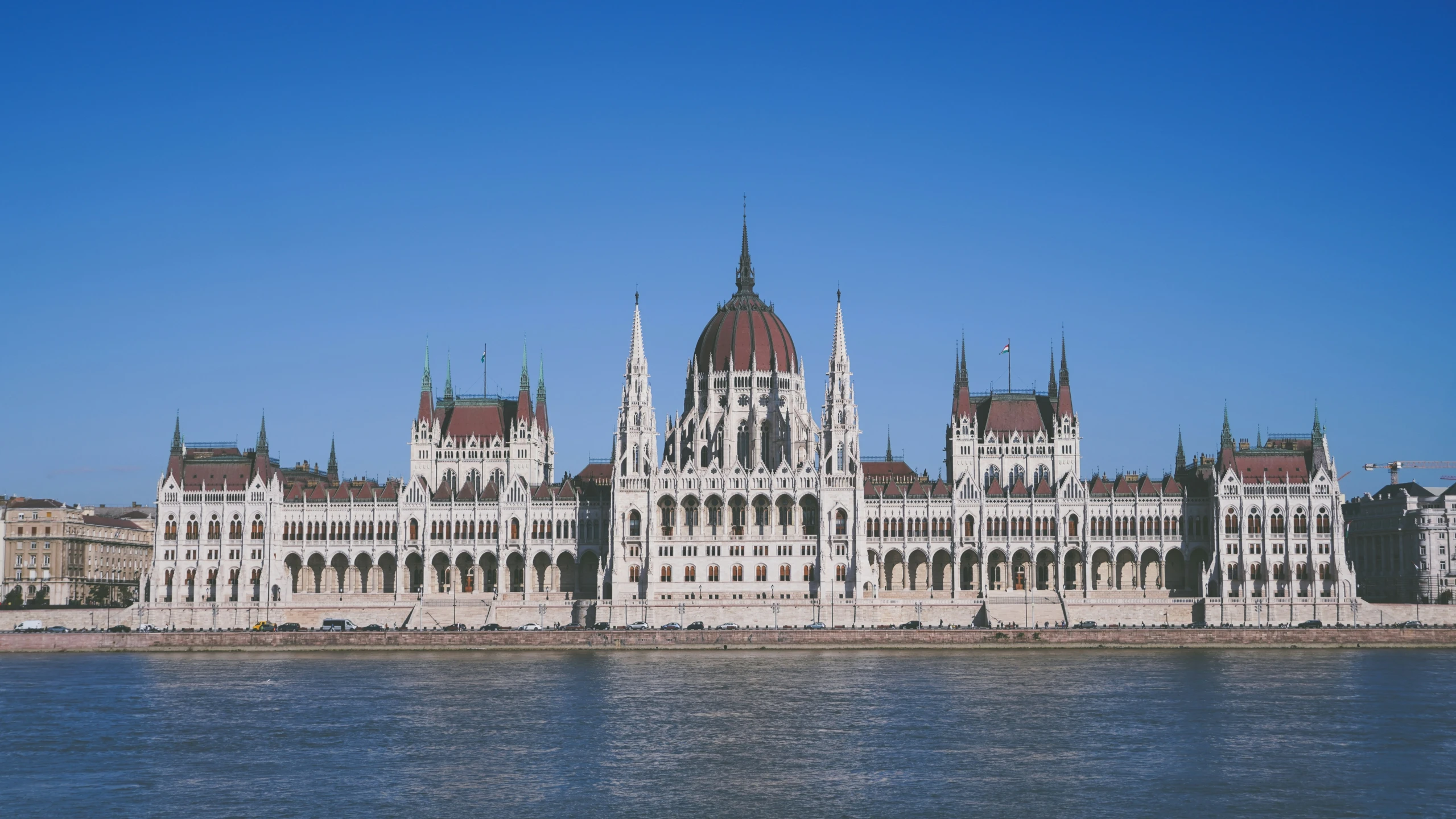 an old building sits in the foreground and is overlooking a body of water