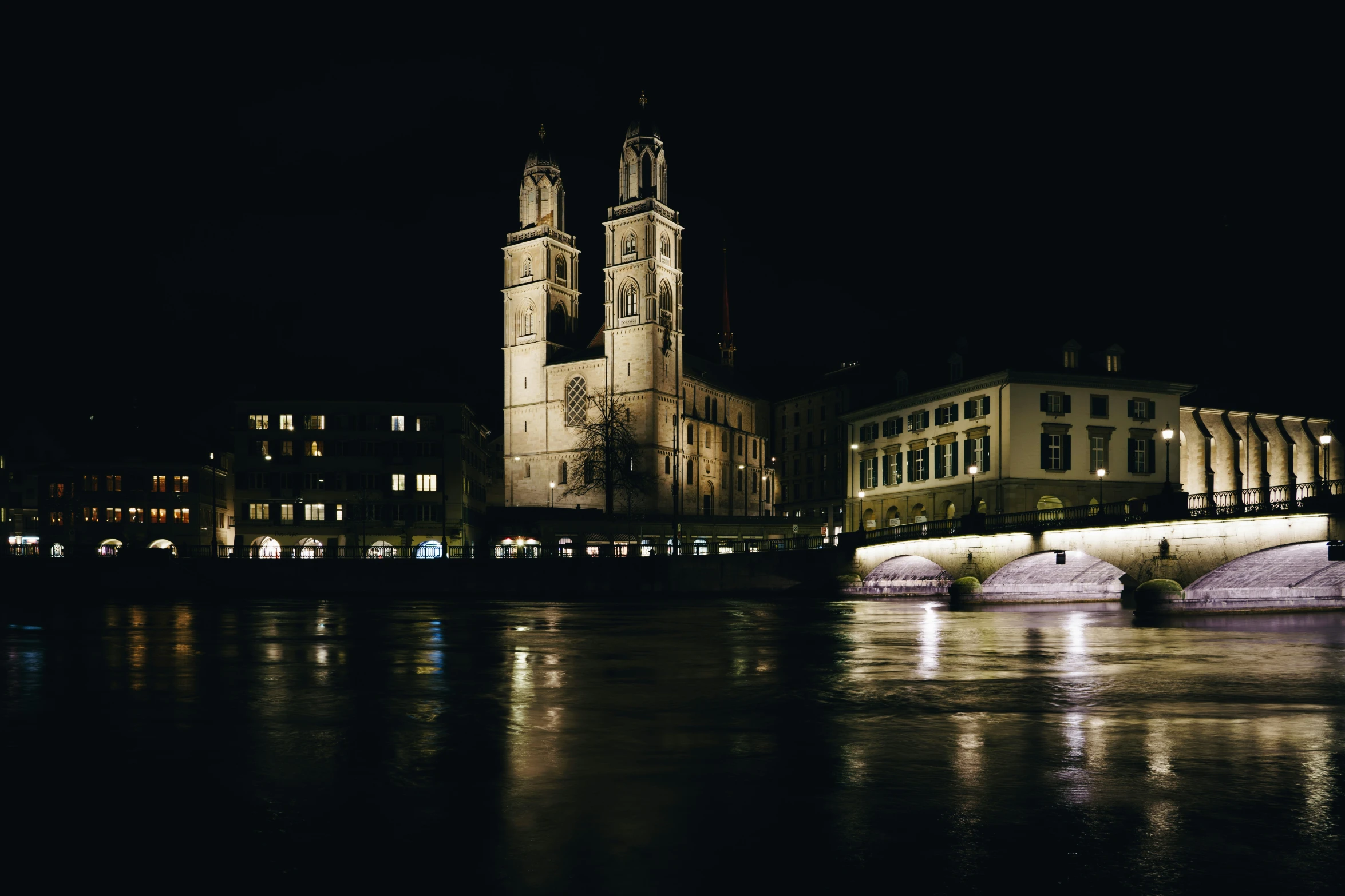 a city at night with lights reflecting on water