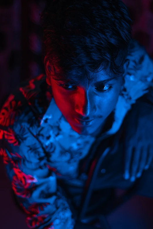 young man with hoodie looking at cell phone in dimly lit room