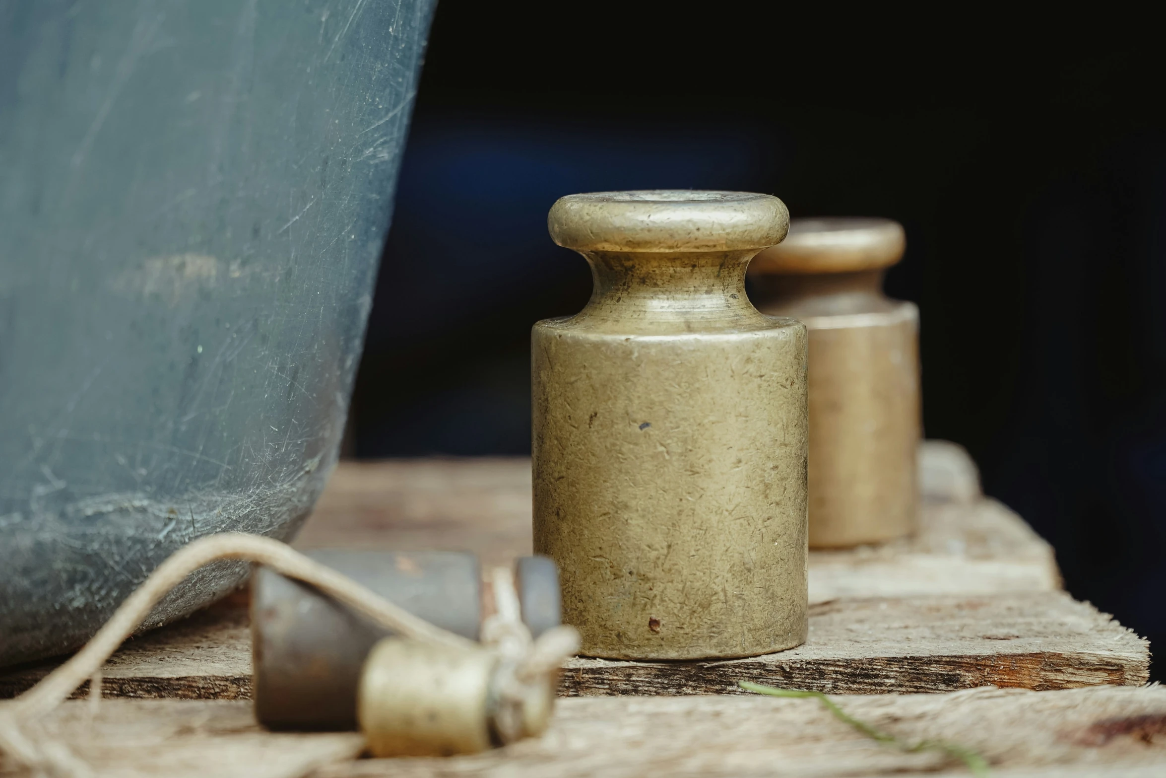 a metal canister with a spout attached and another container next to it