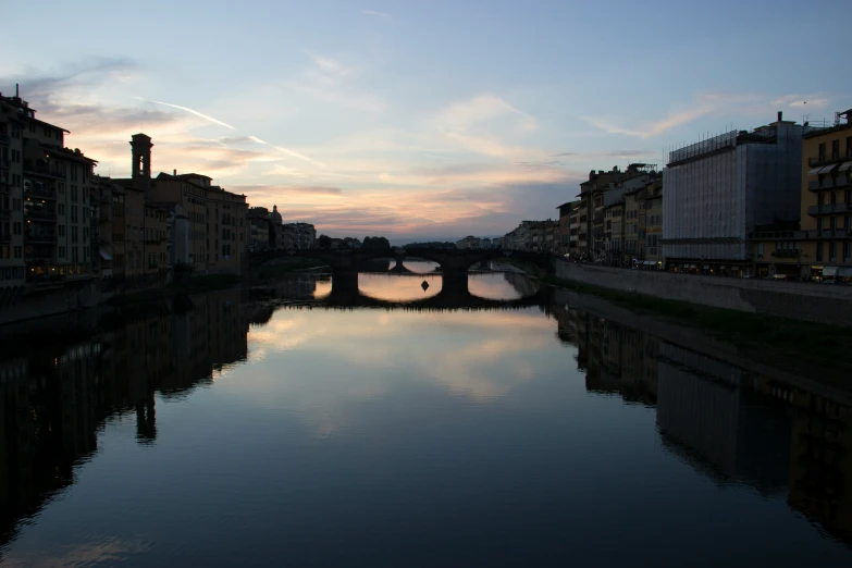 a river with some buildings on both sides and a bridge over it