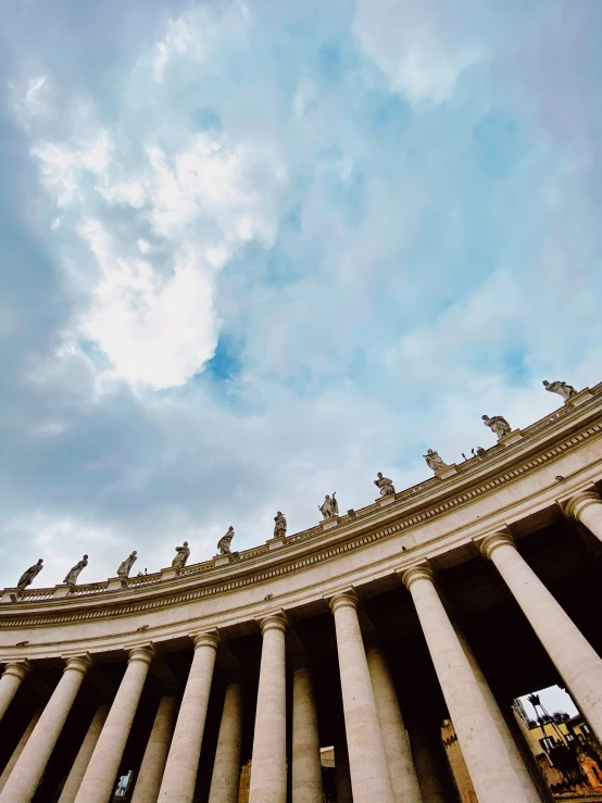 some statues and pillars on the top of a building