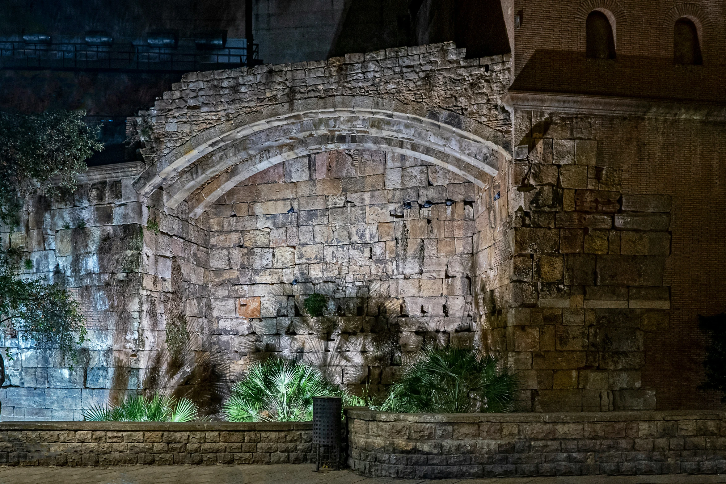 an arched doorway of a stone building at night