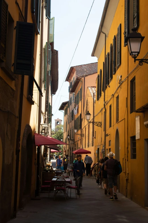 people walking in an alley lined with buildings