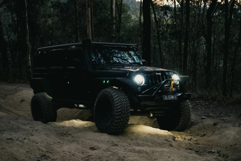 a black jeep driving through some forest