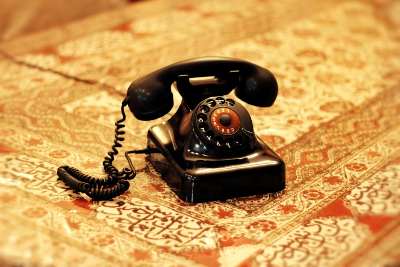 an antique - fashioned phone on a patterned carpet