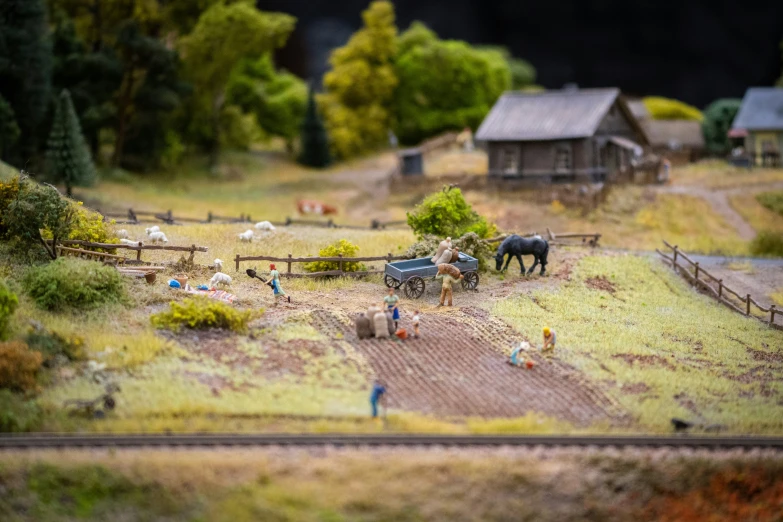 two horses, wagons and other animals in a toy landscape