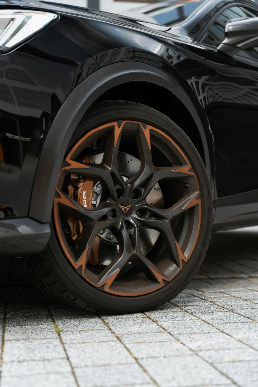 a dark colored car with orange ke calipent on the wheels