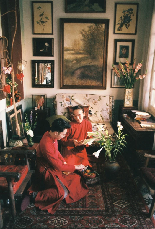 two women sitting on the floor by some flowers