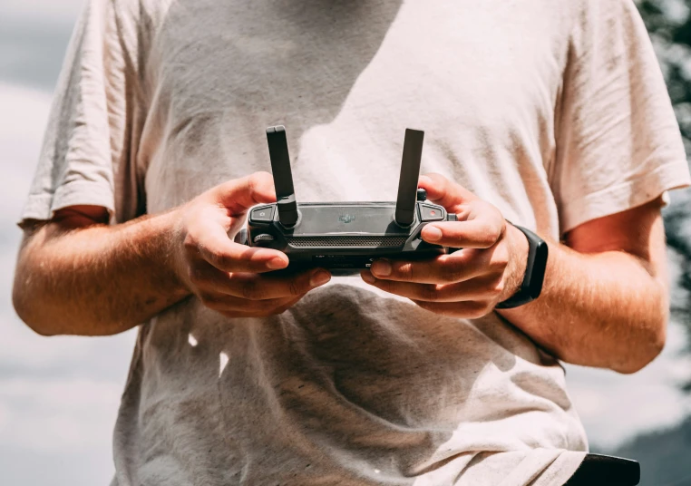 a man holding a pair of small cellphones in his hands