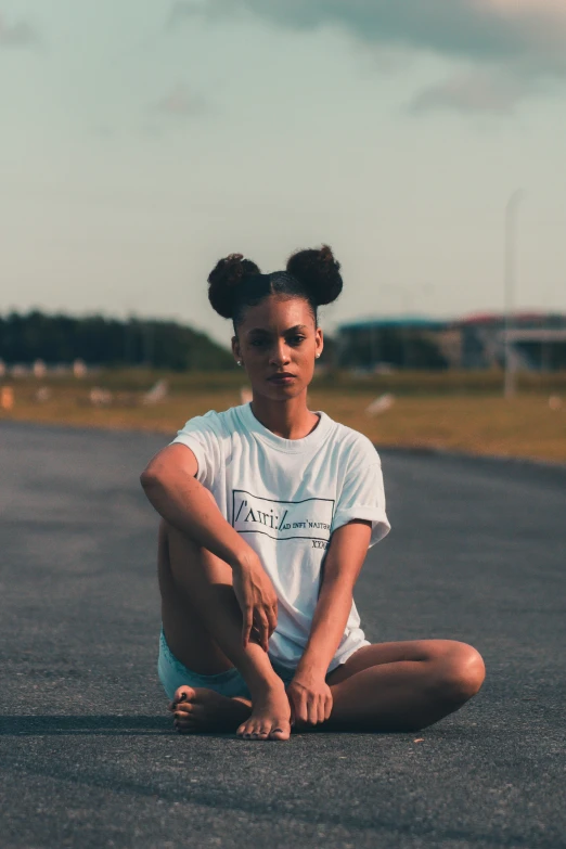 woman sitting on a road with her hand on the ground