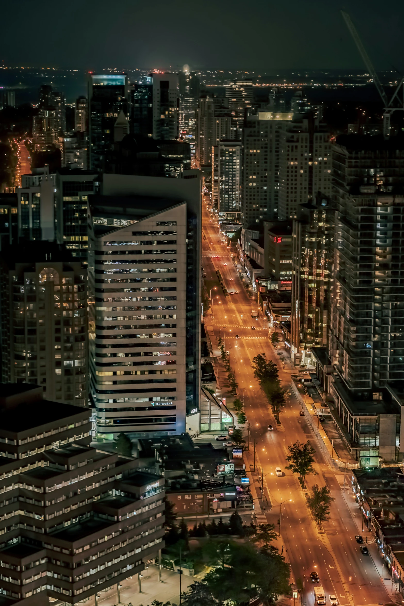 some lights and buildings at night as seen from a skyscr