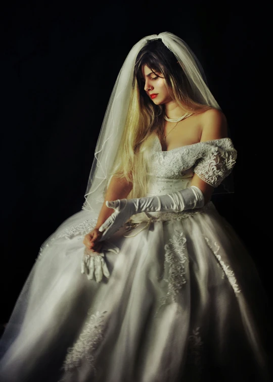 a woman in a wedding dress is wearing gloves
