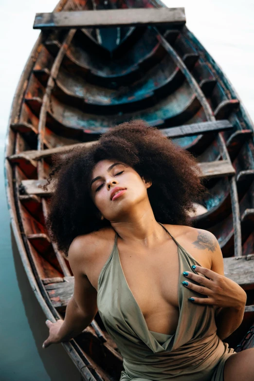 a woman standing next to a boat on a river