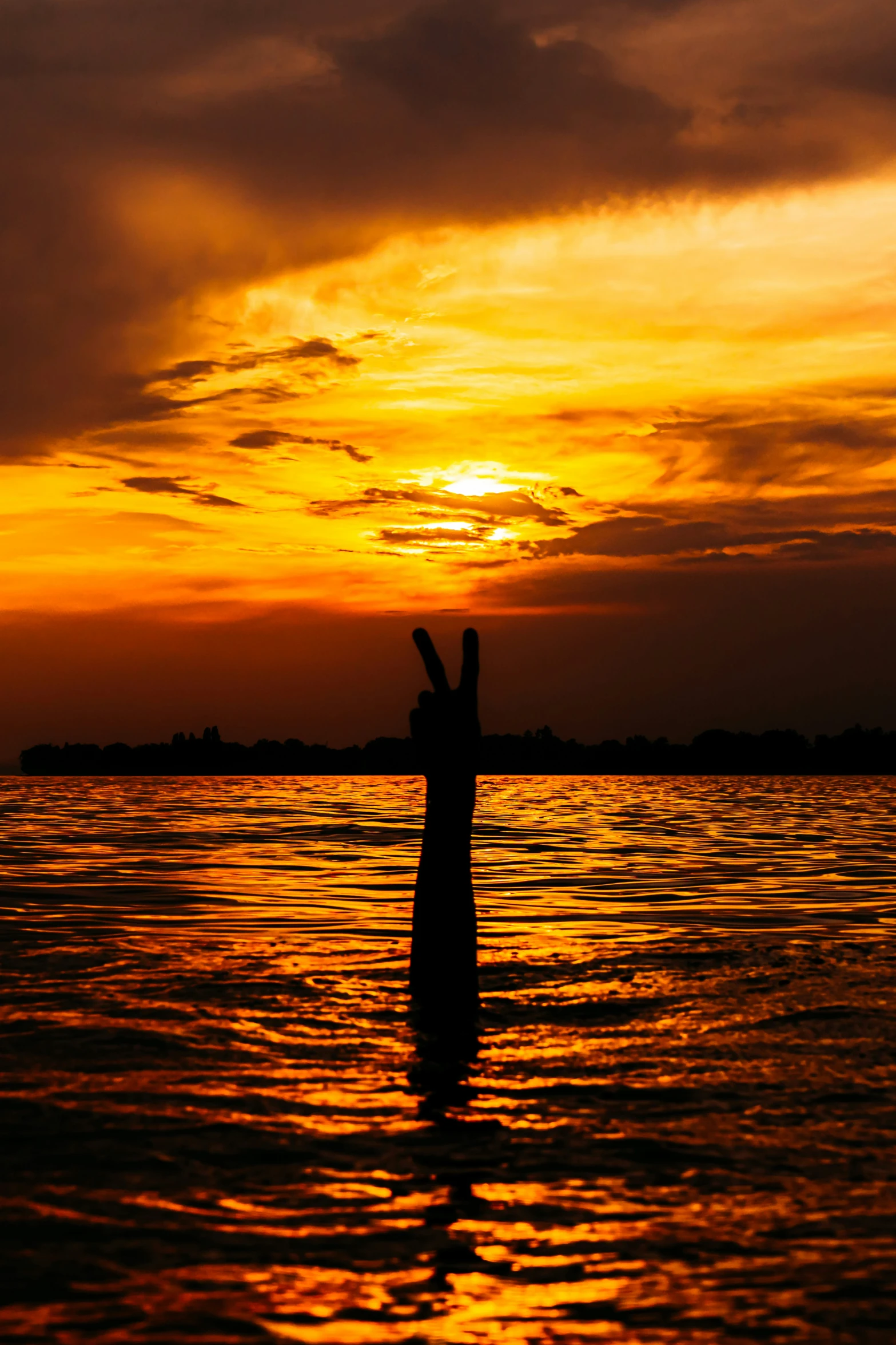 the man is standing in the water holding his hand up