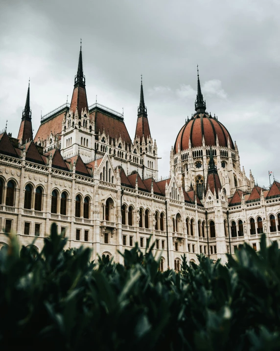 two large buildings with pointed towers under a cloudy sky