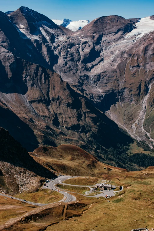 winding road surrounded by mountains on a sunny day