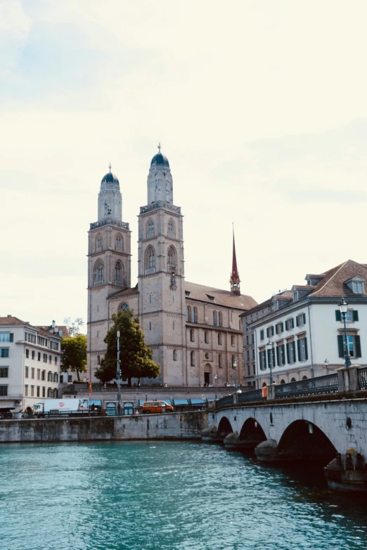 an old building with spires next to a river