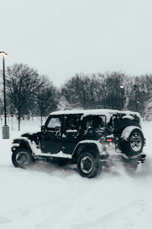 the jeep is on the side of the snowy road