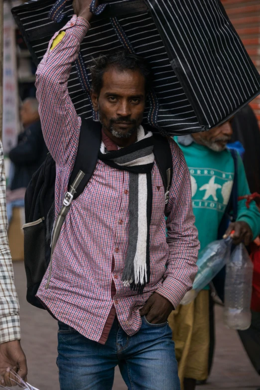 a man carrying items while walking down the street