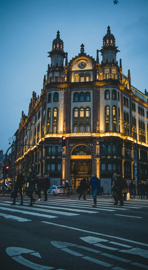 a large building with many people walking on the sidewalk