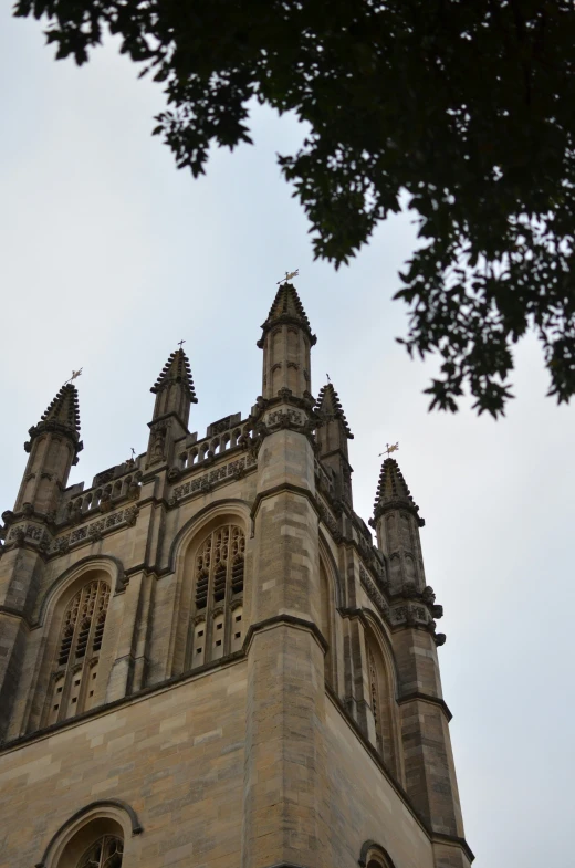 a tall brown building with many windows under a gray sky