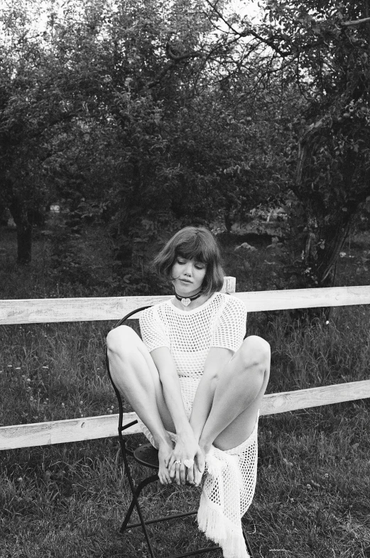 a black and white po of a girl sitting on a chair