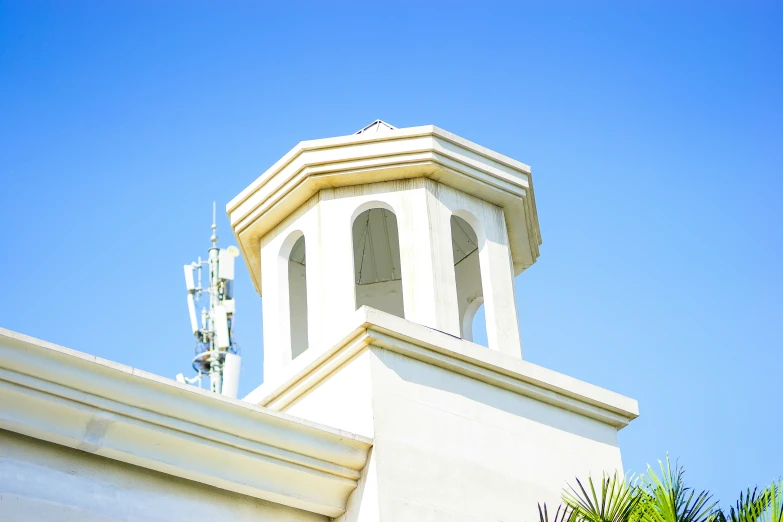 an architectural clock tower with a small weather vein