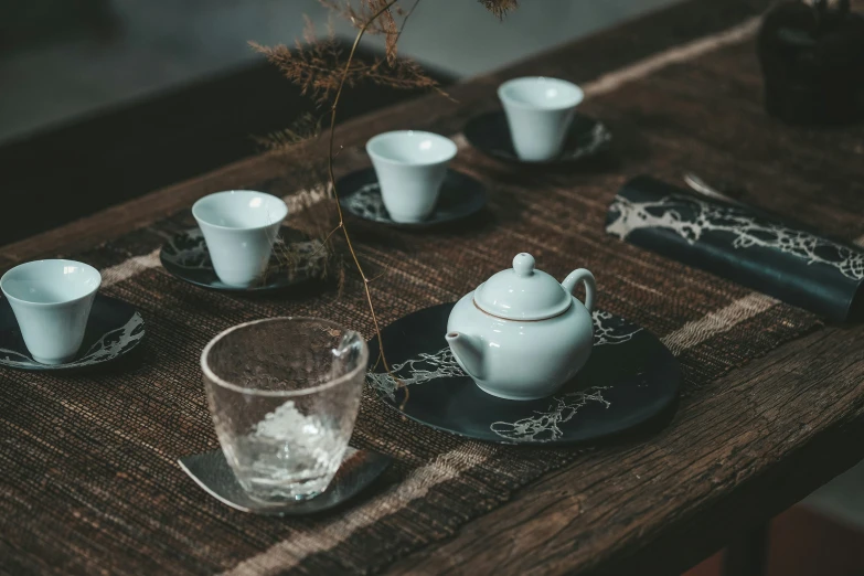 an assortment of cups and dishes sitting on a wooden table