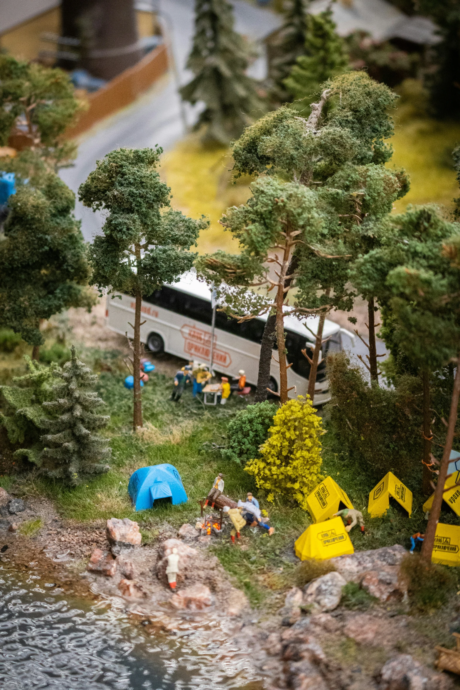 a miniature model of a bus and people next to the water