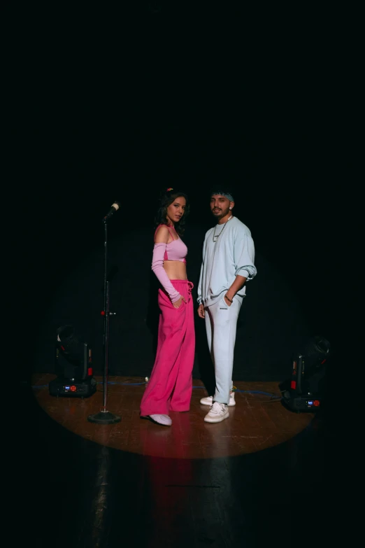 a man and a woman stand on stage during a performance