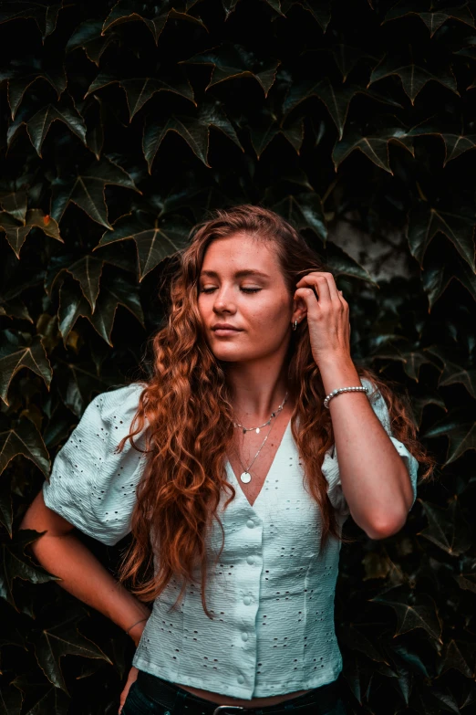 the woman has red curly hair and wears a necklace