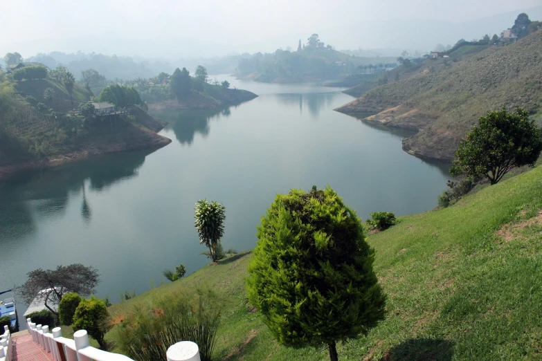 a hill side near a large river surrounded by hills