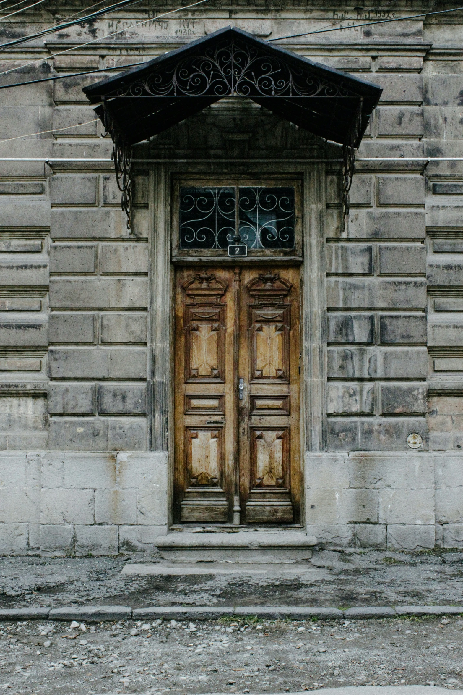 two wooden doors are sitting on a brick wall