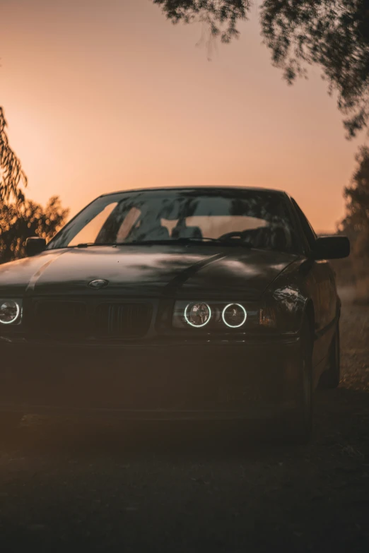 an automobile parked under a tree in the evening