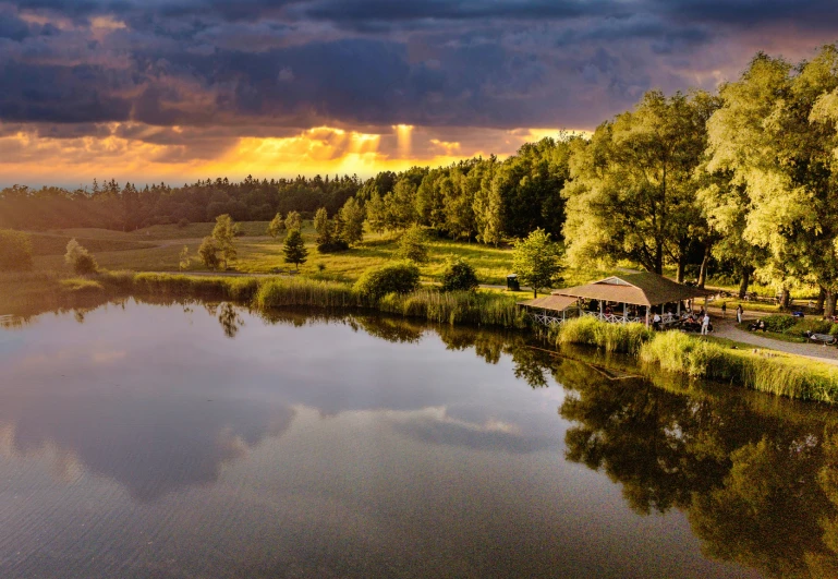 a large lake in the middle of a field near a forest