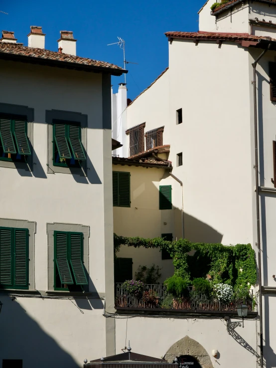 an apartment building with shutters on its front and side