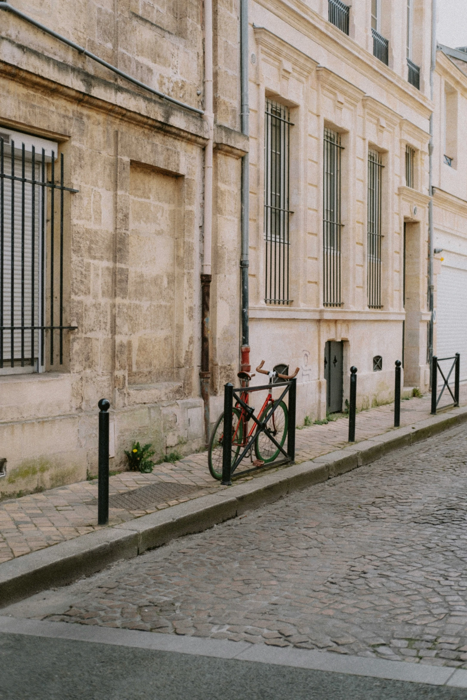 a bike locked to an iron gate by a building