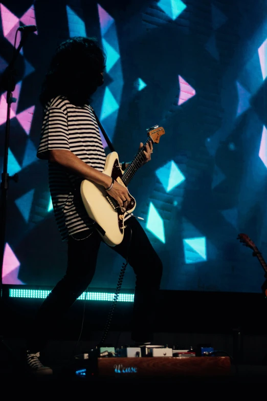 the man is playing a guitar on stage