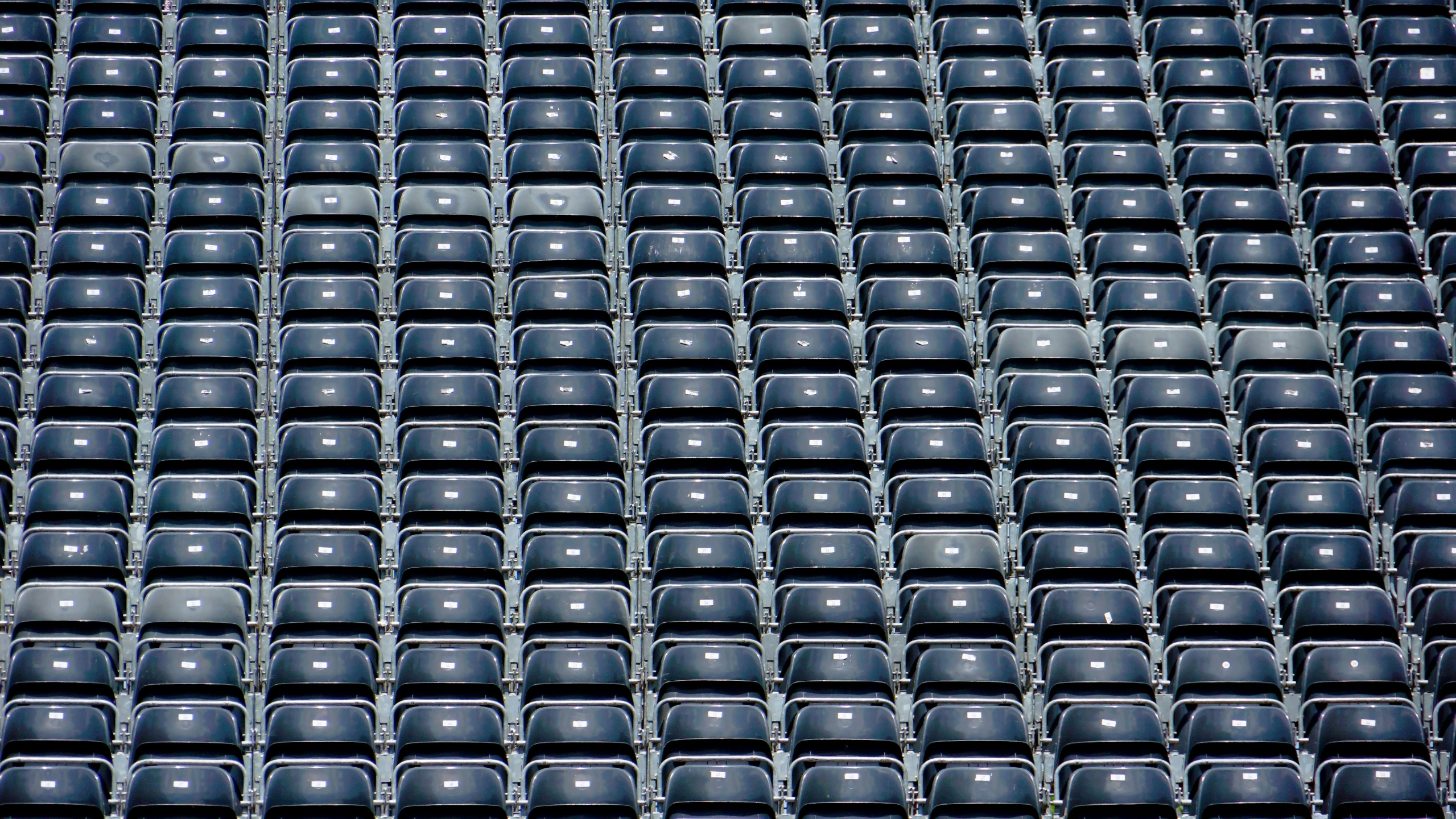 black seats sitting in the stands of an empty stadium