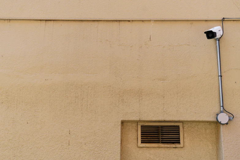 a small camera on a wall behind a window