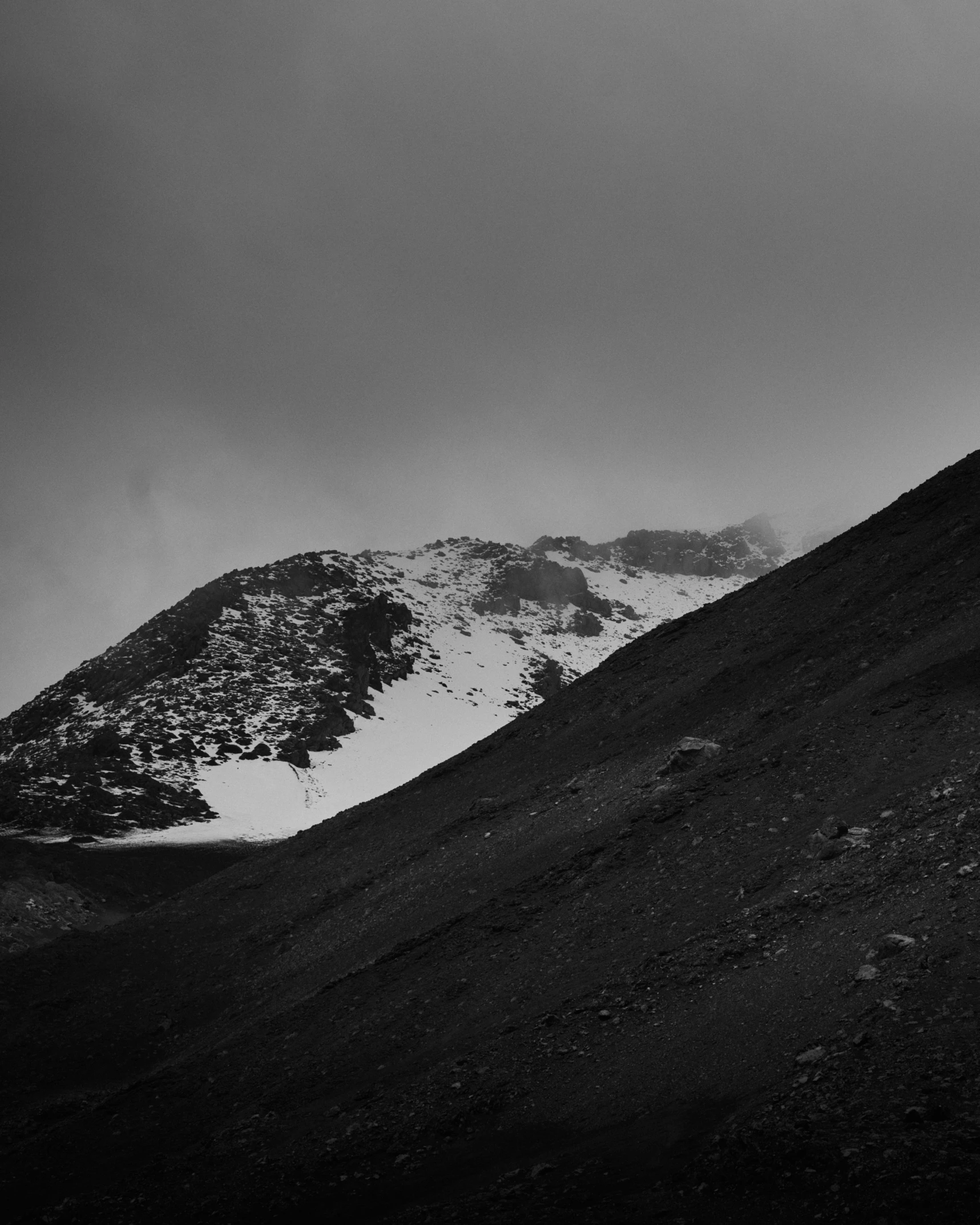 there is a hill that has a few snow on top of it