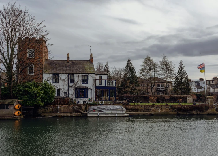 there is a boat on the river in front of houses