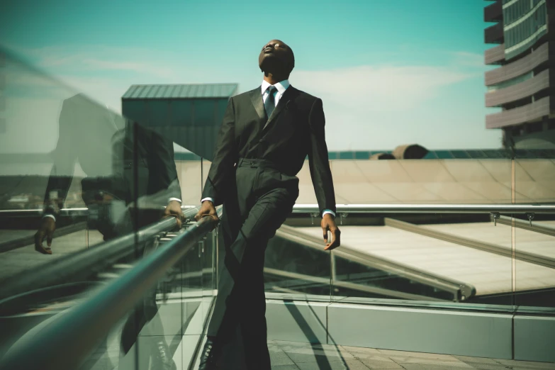 a man with his suit and tie leaning against a railing