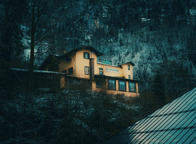 an old house is perched on a wooded hillside