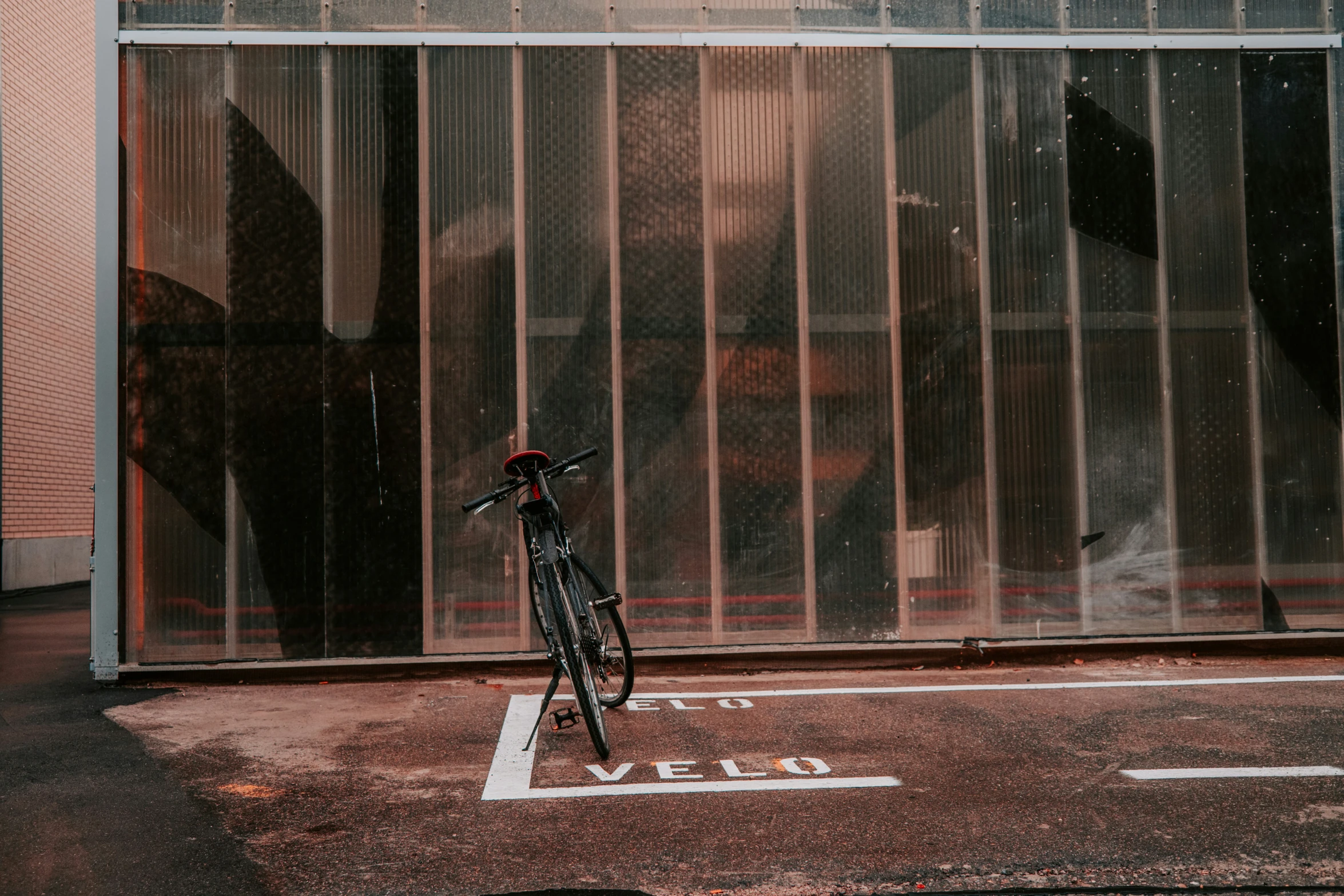 bicycle parked in a parking lot outside a glassed door