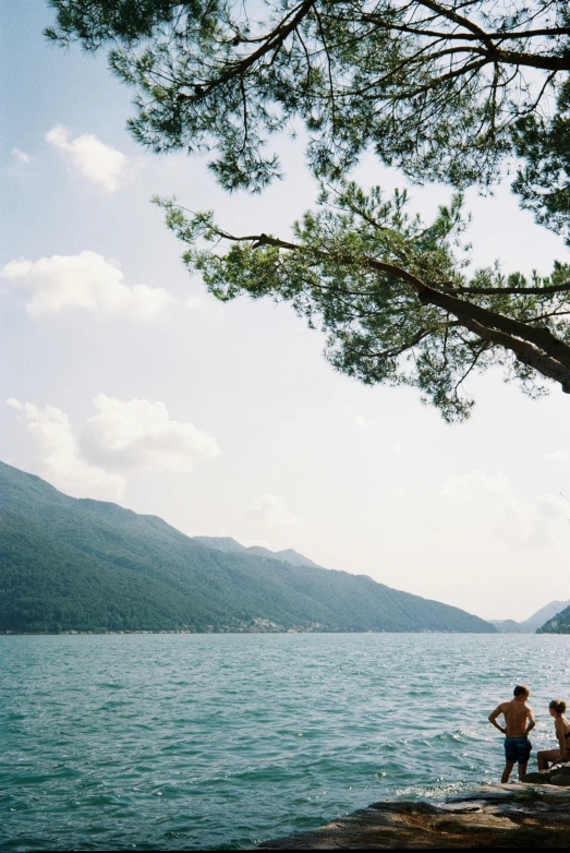 two people standing on the water watching another person