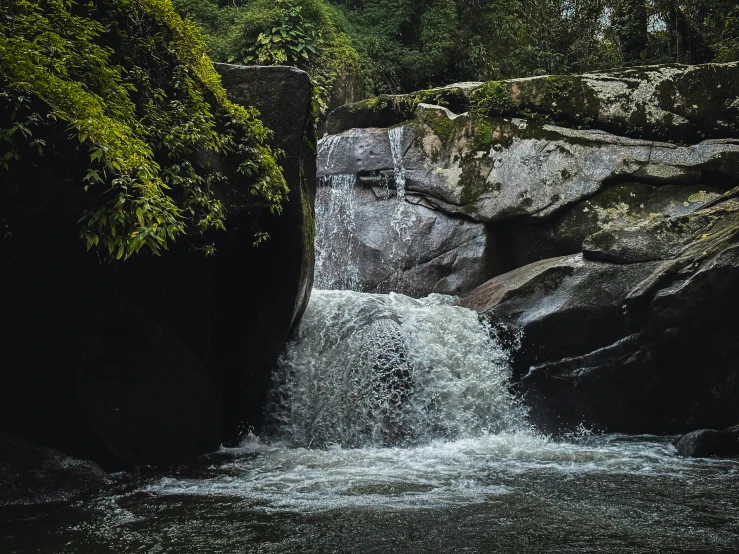 a close up image of a waterfall in a forest